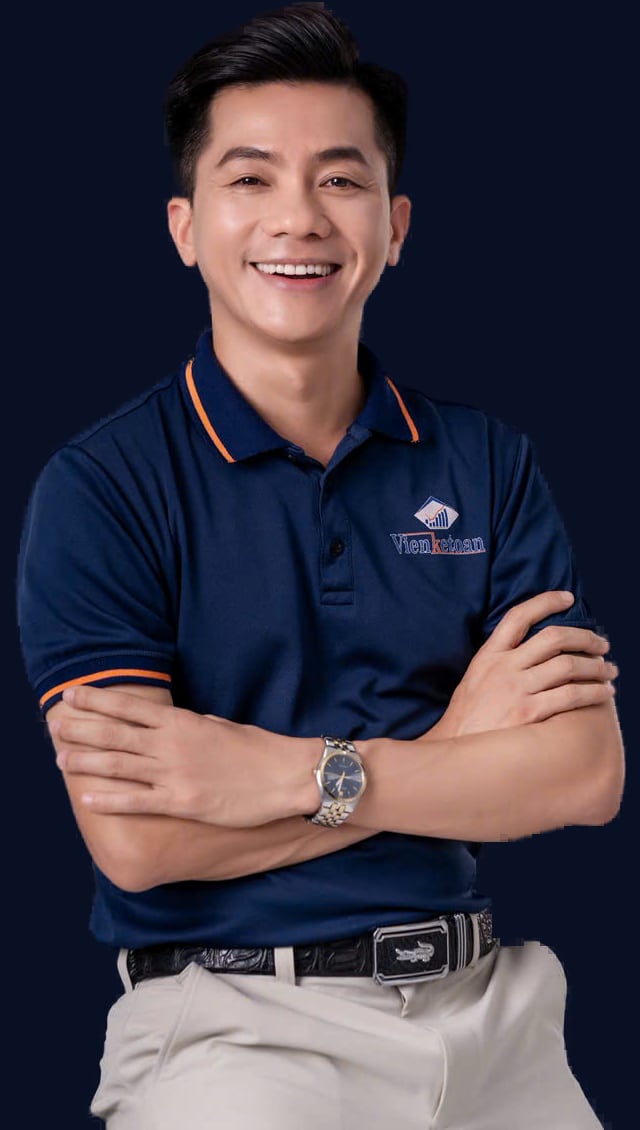 Chân dung Robert Nguyễn Huy trong áo polo navy Viện Kế Toán, khoanh tay và mỉm cười